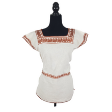 Cargar imagen en el visor de la galería, Blusa grande de corte recto con bordados de hilván tradicionales de Puebla, en color blanco con detalles en pecho, mangas y parte inferior. Hecha por Hilaria Gómez.