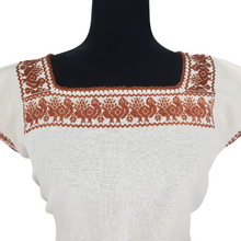 Cargar imagen en el visor de la galería, Blusa grande de corte recto con bordados de hilván tradicionales de Puebla, en color blanco con detalles en pecho, mangas y parte inferior. Hecha por Hilaria Gómez.