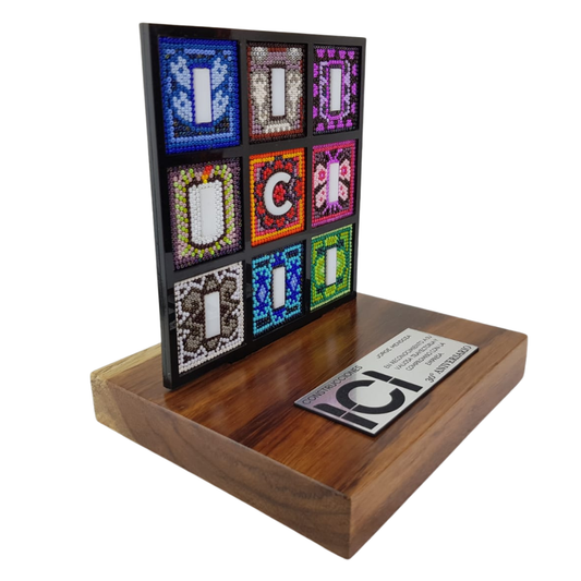 Reconocimiento con artesanía mexicana. Logotipo empresarial decorado con arte wixárika, en trofeo con base de madera y placa metálica personalizada