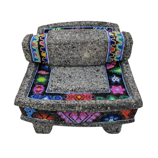Metate de piedra volcánica con decoración wixárika