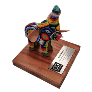 Reconocimiento con artesanía mexicana. Elefante wixárica en trofeo con base de madera y placa metálica personalizada