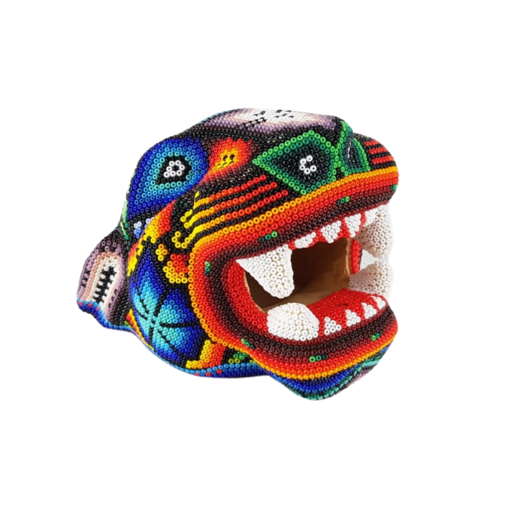 Cabeza de jaguar hecha de madera tallada a mano y decorada con motivos wixárika