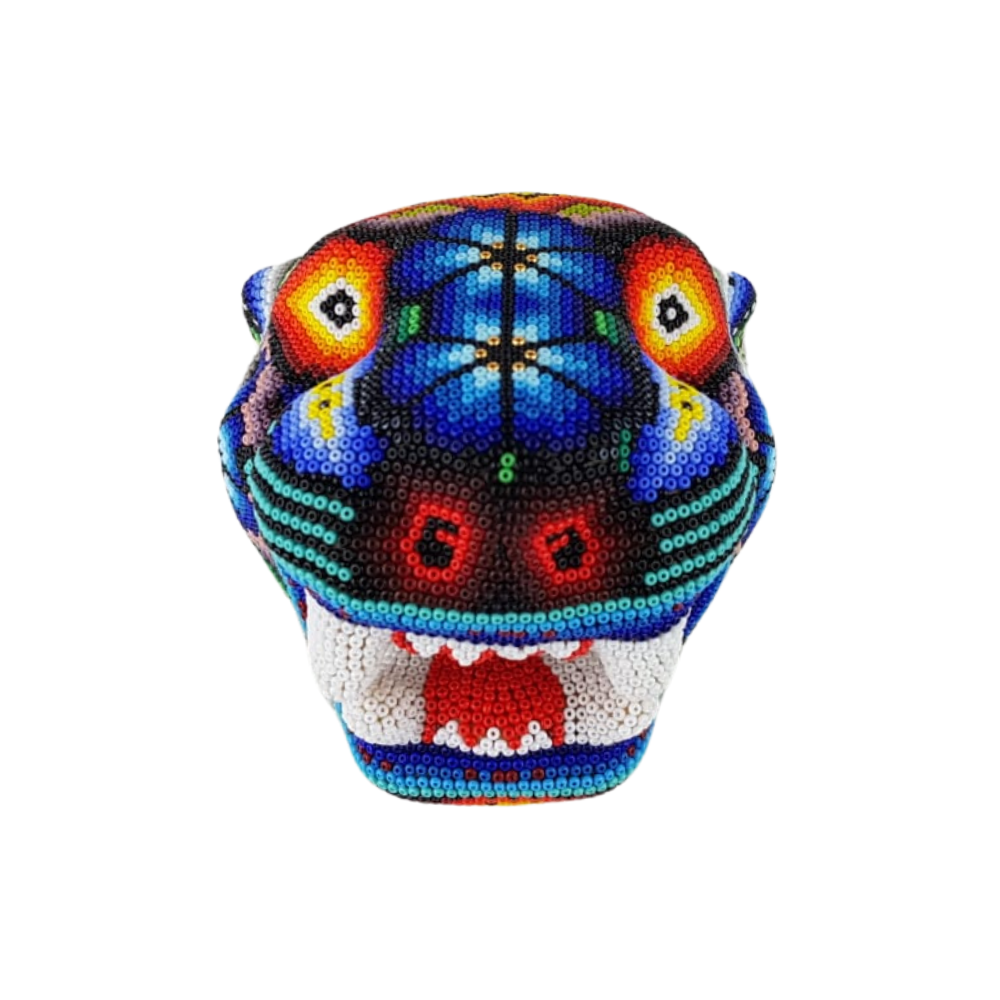Cabeza de jaguar hecha de madera tallada a mano y decorada con motivos wixárika
