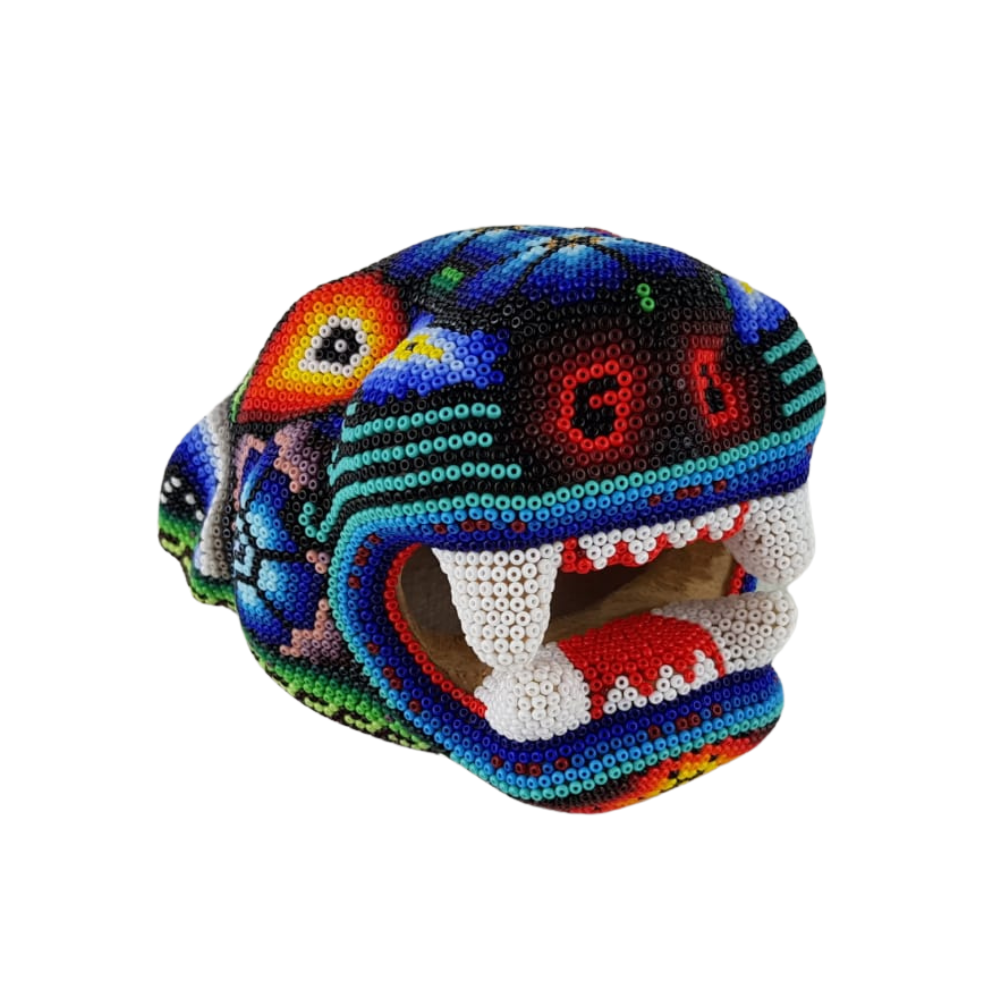 Cabeza de jaguar hecha de madera tallada a mano y decorada con motivos wixárika
