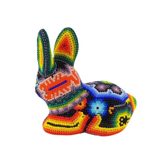 Conejo echado wixárika hecho de papel maché