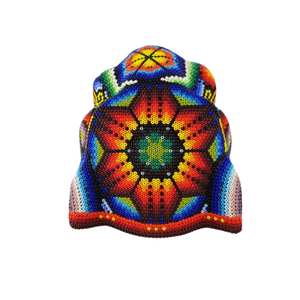 Cabeza de jaguar hecha de madera tallada a mano y decorada con motivos wixárika