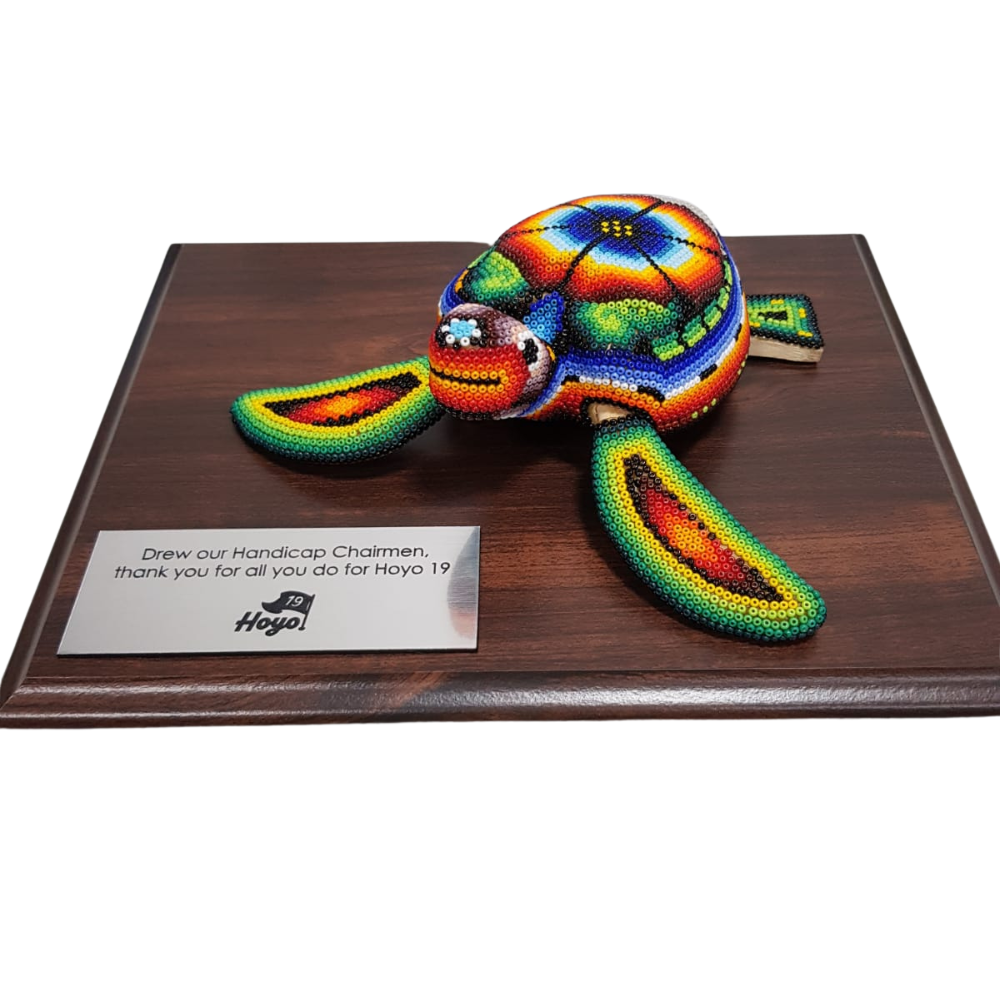 Reconocimiento con artesanía mexicana. Tortuga de madera decorada con arte Wixárica, en trofeo con base de madera y placa metálica personalizada