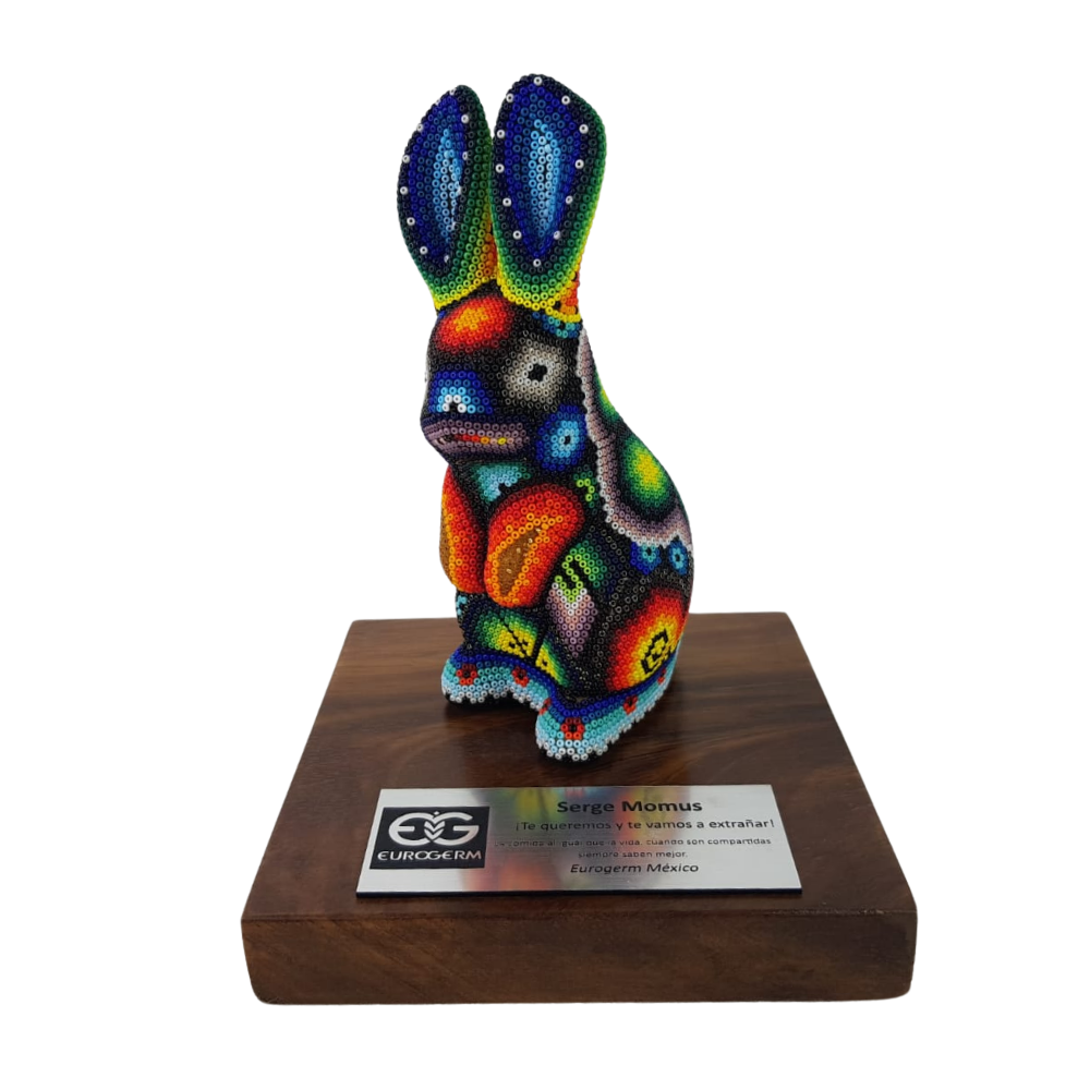 Reconocimiento con artesanía mexicana. Conejo decorado con arte wixárika, en trofeo con base de madera y placa metálica personalizada