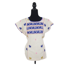 Cargar imagen en el visor de la galería, Blusa grande de corte recto con bordados de hilván tradicionales de Puebla, en color blanco con detalles en pecho, mangas y parte inferior. Hecha por Hilaria Gómez.

