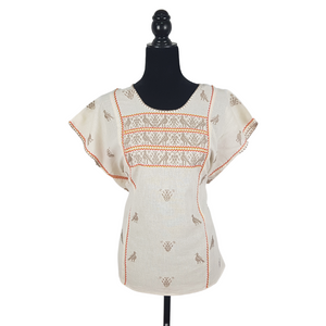 Blusa grande de corte recto con bordados de hilván tradicionales de Puebla, en color blanco con detalles en pecho, mangas y parte inferior. Hecha por Hilaria Gómez.
