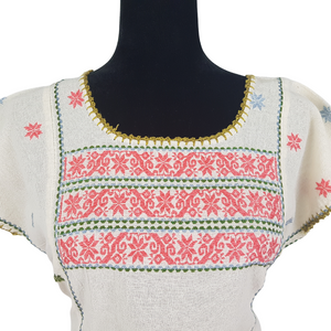 Blusa grande de corte recto con bordados de hilván tradicionales de Puebla, en color blanco con detalles en pecho, mangas y parte inferior. Hecha por Hilaria Gómez.