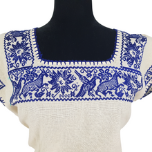 Cargar imagen en el visor de la galería, Blusa grande de corte recto con bordados de hilván tradicionales de Puebla, en color blanco con detalles en pecho, mangas y parte inferior. Hecha por Hilaria Gómez.
