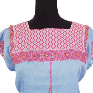 Blusa de lino con bordados Tzotziles, adornada con perlas de ambar, de Santa Martha, Chiapas. Color azul con detalles rosas. Hecha por Oliverio Gómez.