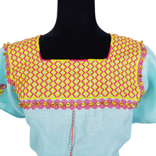 Cargar imagen en el visor de la galería, Blusa de lino con bordados Tzotziles, adornada con perlas de ambar, de Santa Martha, Chiapas. Color azul agua con detalles en amarillo y rosa. Hecha por Oliverio Gómez.
