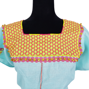 Blusa de lino con bordados Tzotziles, adornada con perlas de ambar, de Santa Martha, Chiapas. Color azul agua con detalles en amarillo y rosa. Hecha por Oliverio Gómez.