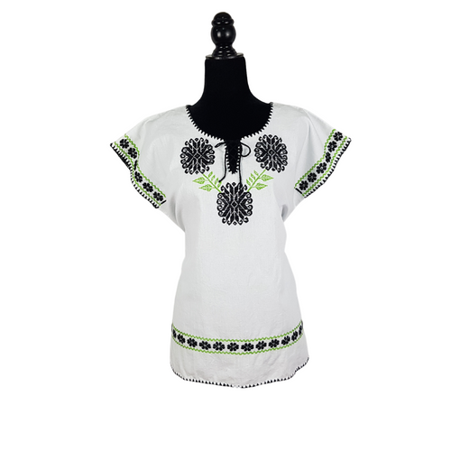 Blusa grande de corte recto con bordados de hilván tradicionales de Puebla, en color blanco con detalles en pecho, mangas y parte inferior. Hecha por Hilaria Gómez.